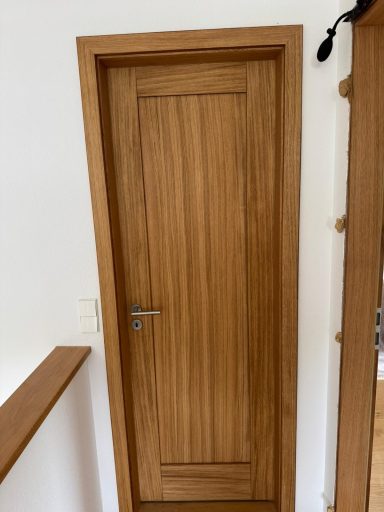 Holztür mit vertikaler Holzmaserung in einem modernen Raum.